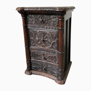 Cassettiera antica in legno di pino annerito intagliato
