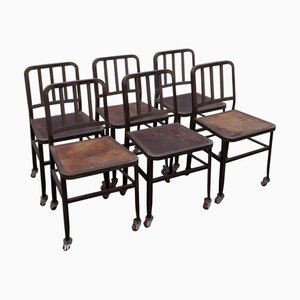 Sillas industriales vintage de hierro en azul marino con ruedas con asiento de madera de Emeco, años 70. Juego de 6