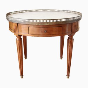 Mesa redonda de madera con tablero de mármol blanco