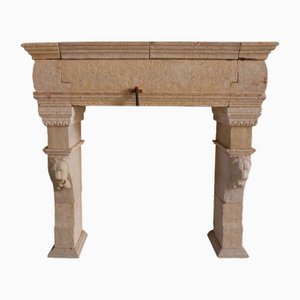 Chimenea francesa de piedra caliza, siglo XX con máscaras de leones talladas