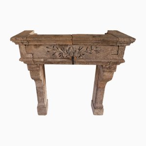 Chimenea francesa de piedra caliza tallada de principios del siglo XX con frisos de laurel