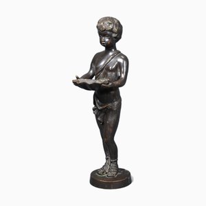 Escultura de bronce de los años 60 que representa a un niño ofreciendo una concha