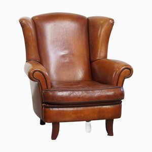 Poltrona in pelle di pecora con colori caldi e finitura raffinata con bordino nero