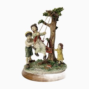 Escultura de niños en un columpio de Capodimonte, años 60