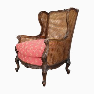Antique Carved Wing Chair with Cane Sides, 1900