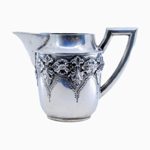 Silberne Teekanne mit Blumenmotiven und geradem Griff