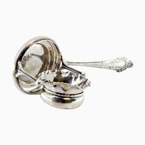 Silbernes Teesieb mit wellenförmigem Behälter in Schalenform und muschelförmigem Griff mit Reliefs