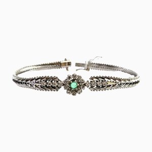 Bracelet en or blanc avec maillons en forme de chevrons, rosace centrale avec émeraude et diamants taille brillant