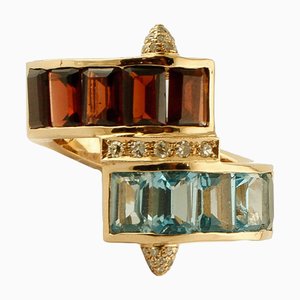 Anillo de oro amarillo con diamantes y topacios azul claro