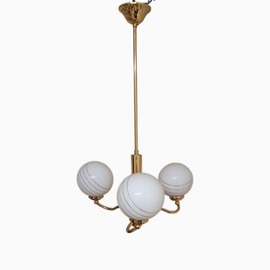 Lámpara colgante vintage con marco de metal dorado y tres bolas de vidrio blanco con decoración dorada, años 70