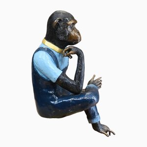 Estatua de bronce de mono sentado