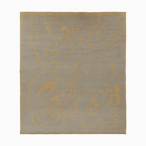 Alfombra en beige con motivos curvados dorados de Rug & Kilim