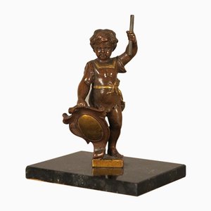 Escultura de putti antigua de bronce con escudo y cayado sobre base de mármol