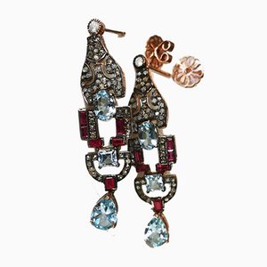 Aretes de oro y plata adornados con rubíes topacios azules y diamantes. Juego de 2