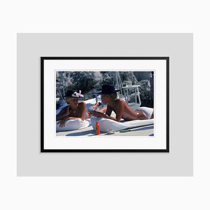 Sunbathing in Antibes Oversize C Print Framed in Black by Slim Aarons