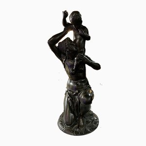 Frau, die eine Kinderstatue in Bronze trägt