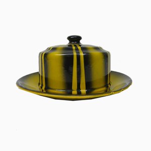 Plato de mantequilla esmaltado en negro y amarillo con decorado en spray, años 20