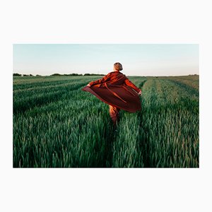 Igor Ustynskyy, Donna in cappotto rosso che cammina nel campo al tramonto, Carta fotografica