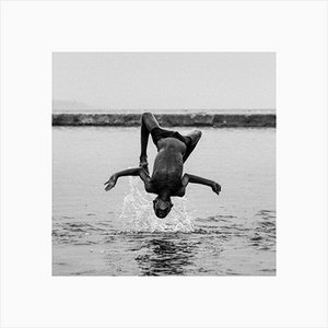 Nikunj Rathod / Eyeem, imagen al revés de un niño sin camisa saltando sobre el lago contra el cielo despejado, papel fotográfico
