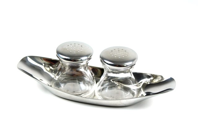 mid-century wood and metal salt and pepper shakers on a stand